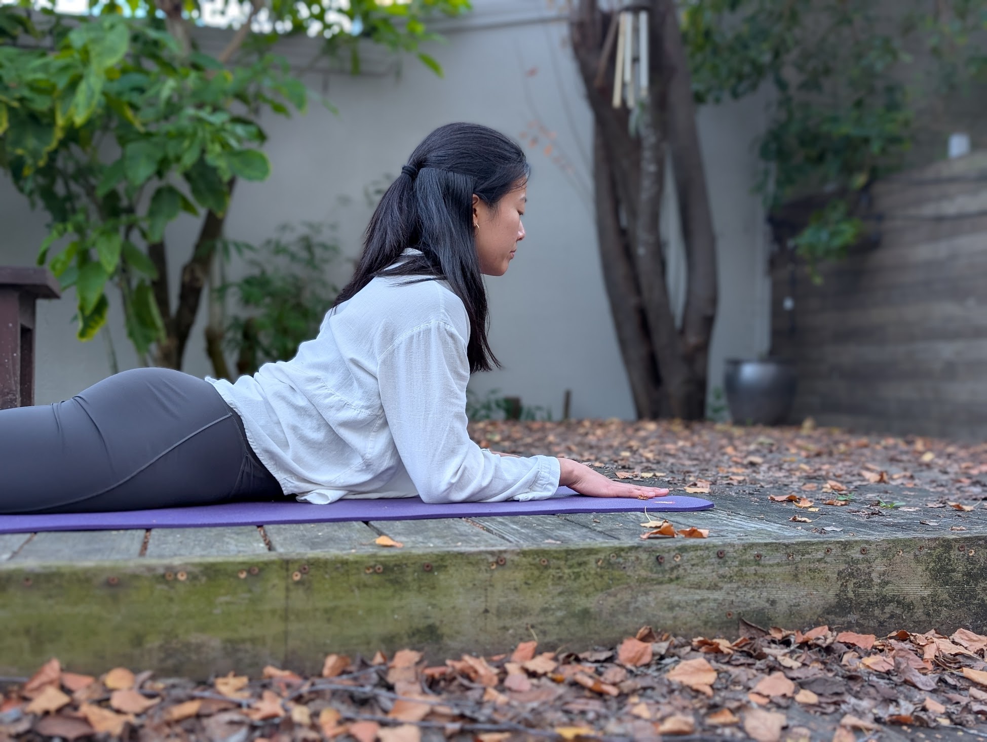Julia in sphinx pose outdoors on a wooden deck